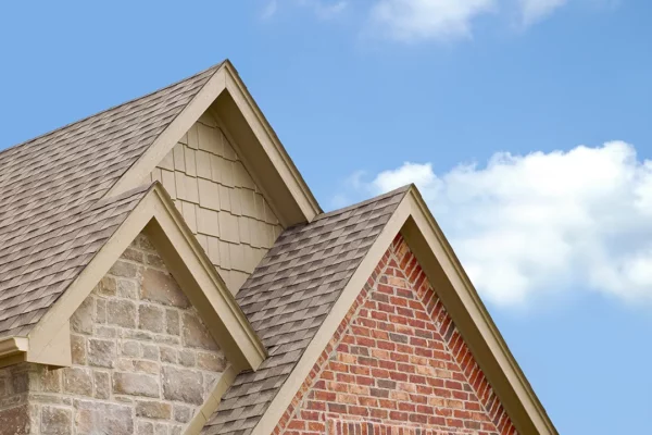 roofing-gallery-2 Close-up of a beautifully installed roof on a home with brick and stone accents, showcasing expert craftsmanship and durable roofing materials.