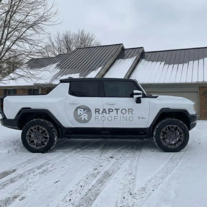 Raptor Roofing truck parked in front of a standing seam metal roof installation in Greenwood Indiana during winter