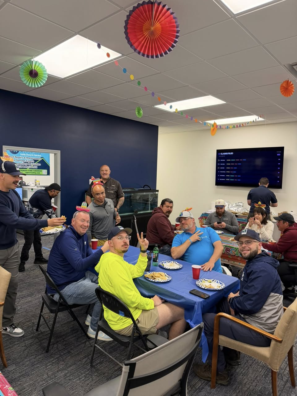 Raptor Roofing team members and crew leaders gathered around a table