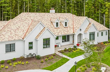 Premium synthetic slate roof on a light exterior home with wooded surroundings