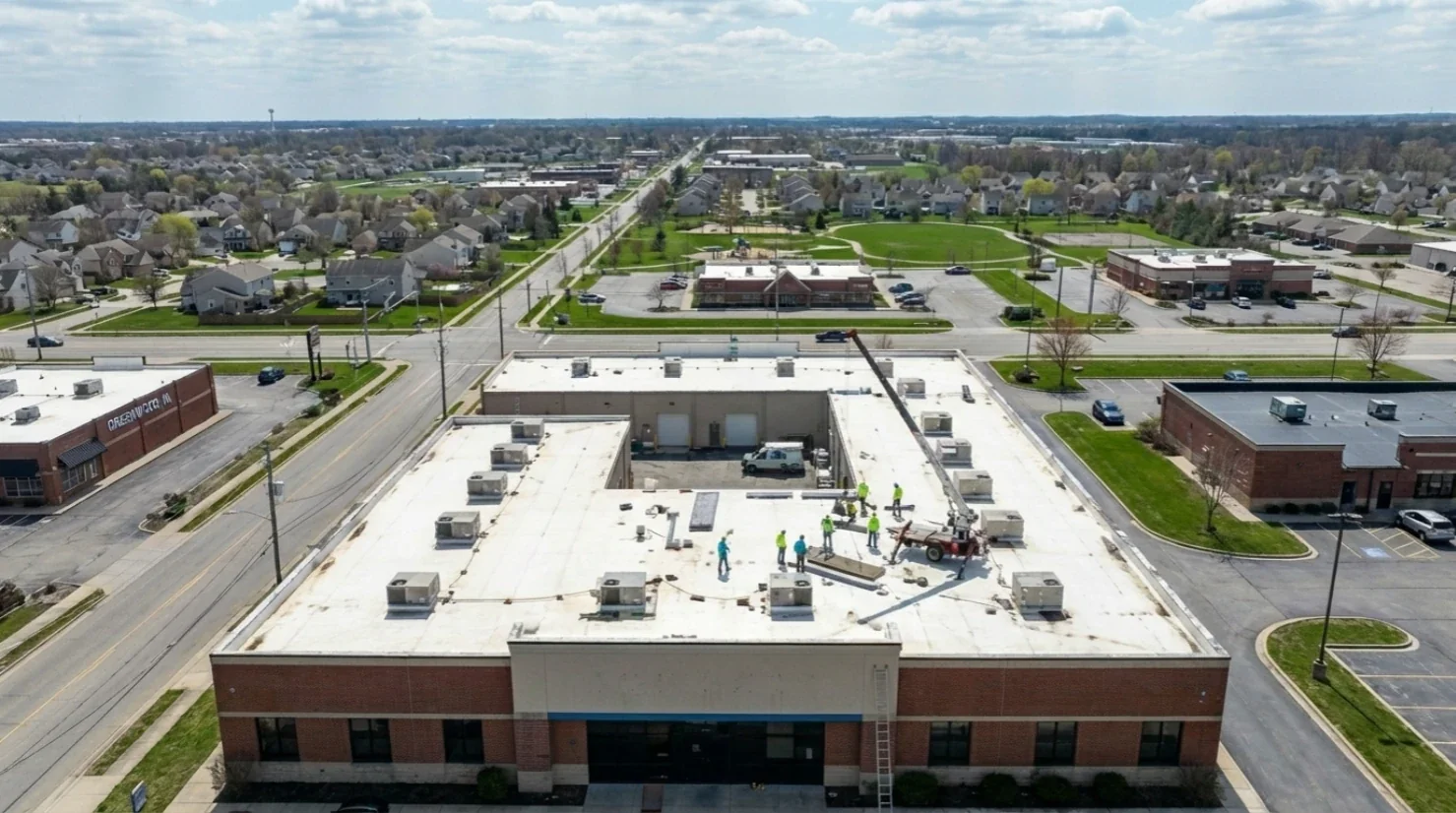 White commercial low slope roof condition review before coating or replacement