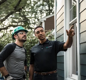 Contractors reviewing James Hardie siding details on a home exterior