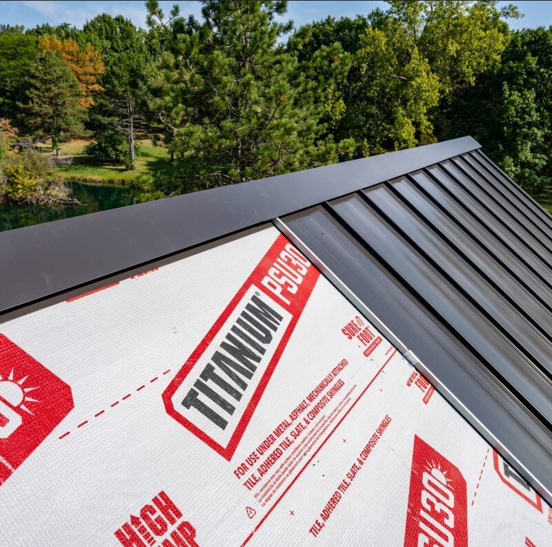 Owens Corning Titanium underlayment beneath a partially installed black metal roof