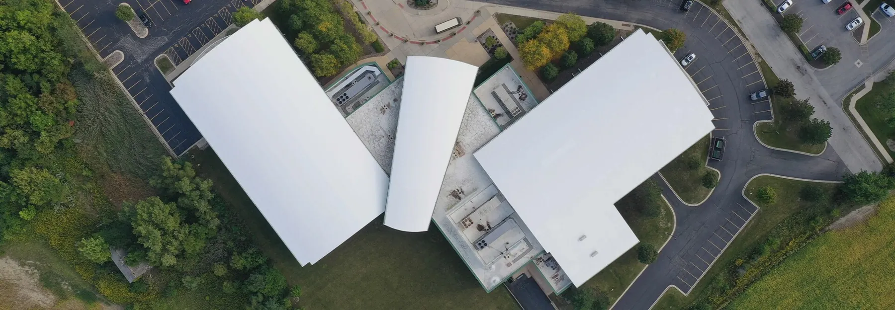 Aerial view of a sports facility with bright white restored roof sections