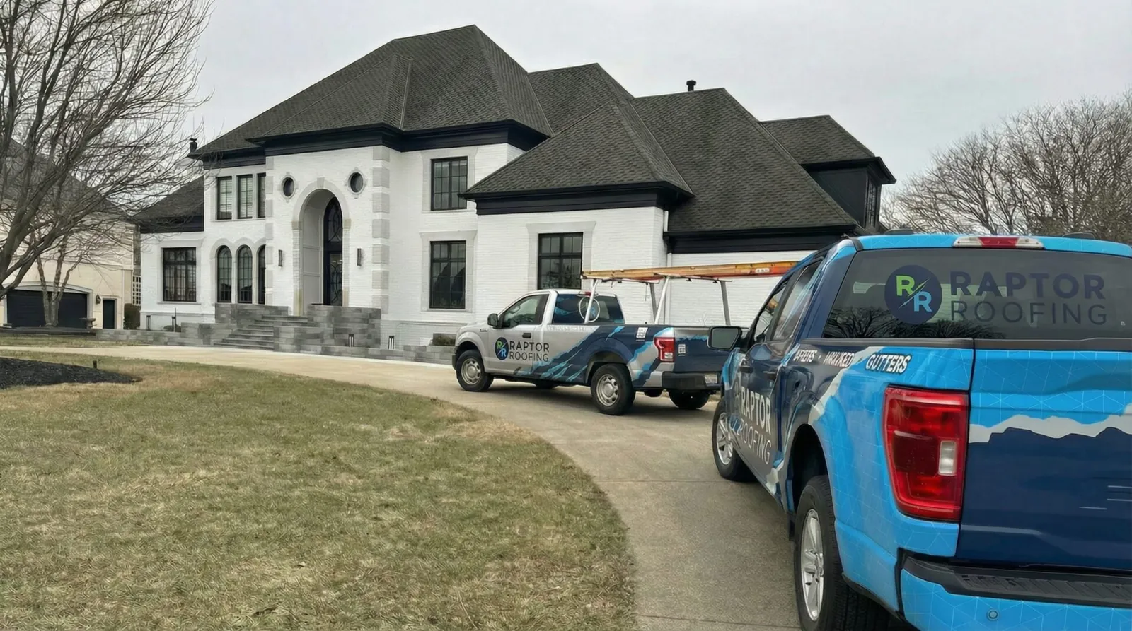 Completed Central Indiana roof replacement with Raptor Roofing trucks at the home